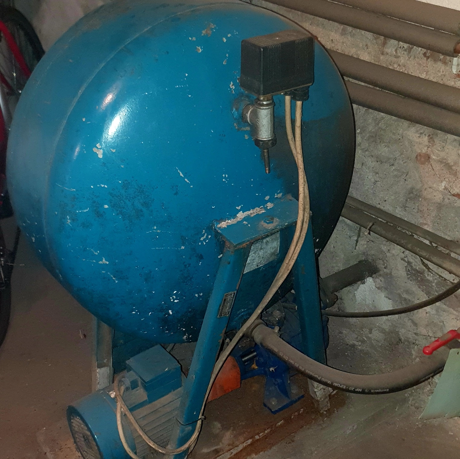 Starší domácí vodárna Darling ve&nbsp;sklepě rodinného domu, čerpadlo s&nbsp;tlakovou nádobou a&nbsp;potrubím, známky používání a&nbsp;mnohaletého provozu